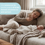 Jeune maman allongée avec son bébé, illustrant la fatigue post-partum et le besoin en fer et énergie.